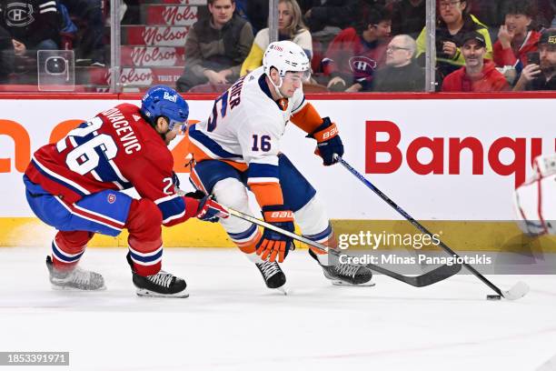 Julien Gauthier of the New York Islanders skates the puck against Johnathan Kovacevic of the Montreal Canadiens during the third period at the Bell...