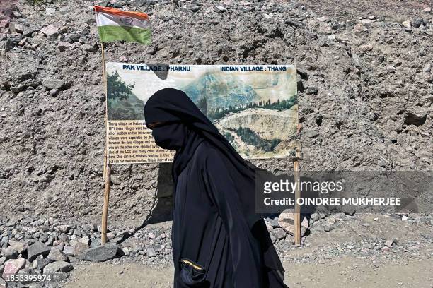 In this photograph taken on September 1 a burqa-clad woman walks near the Line of Control - the border between India and Pakistan, in Thang.