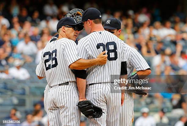 Manager Joe Girardi of the New York Yankees talks with Preston Claiborne during a game against the Tampa Bay Rays at Yankee Stadium on SeptemberJune...