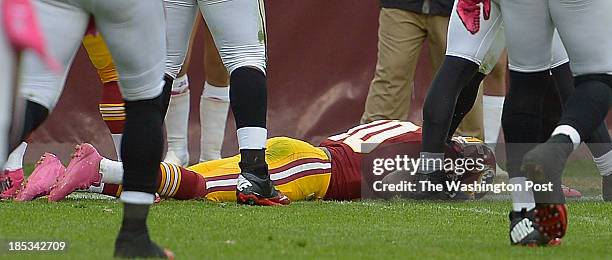 Washington's quarterback Robert Griffin III lays on the ground after getting a concussion in the 3rd quarter as the Washington Redskins play the...