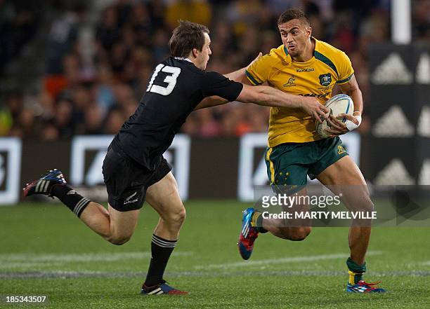 Peter Betham of Australia fends off Ben Smith of New Zealand during the Bledisloe Cup rugby union match between the New Zealand All Blacks and...