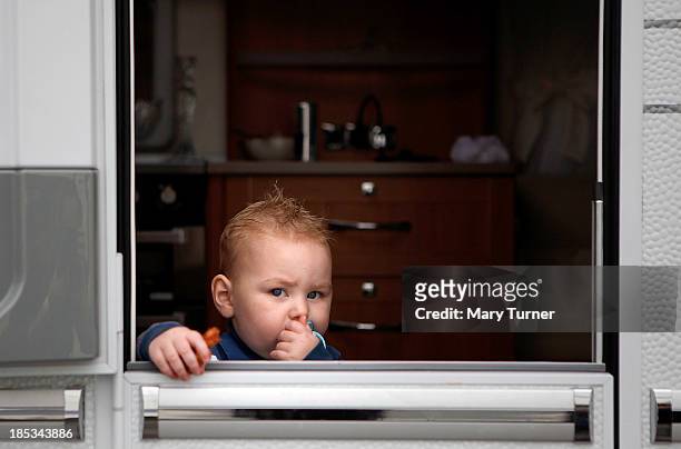 Young child looks out of the door of his family's trailer, on the road leading up to the the Dale Farm site on October 18, 2013 in Crays Hill,...