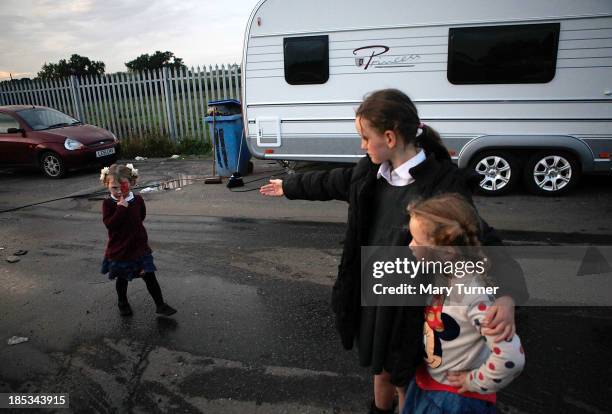 Three young girls play together on the road leading up to the Dale Farm site on October 18, 2013 in Crays Hill, England. Two years on from the mass...