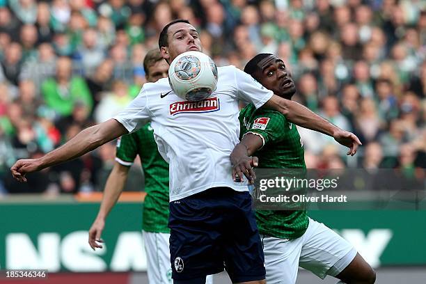 Cedrick Makiadi of Bremen and Nicolas Hoefler of Freiburg compete for the ball during the First Bundesliga match between SV Werder Bremen and SC...