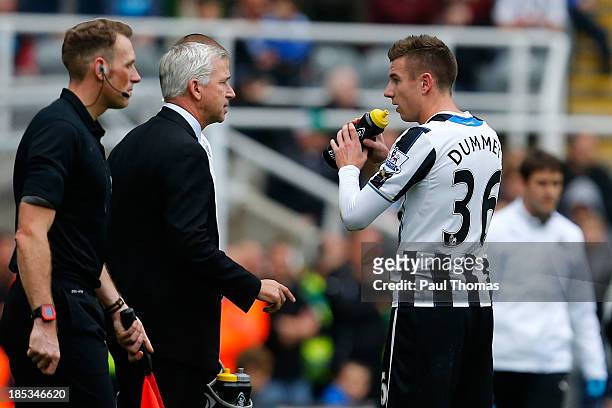 Manager Alan Pardew of Newcastle talks to his player Paul Dummett during the Barclays Premier League match between Newcastle United and Liverpool at...