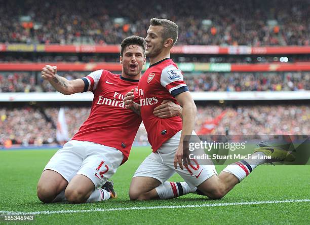 Jack Wilshere celebrates scoring his goal with Olivier Giroud during the match at Emirates Stadium on October 19, 2013 in London, England.