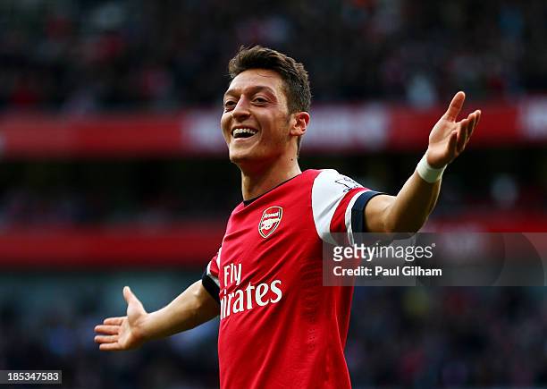 Mesut Oezil of Arsenal celebrates as he scores their second goal during the Barclays Premier League match between Arsenal and Norwich City at...