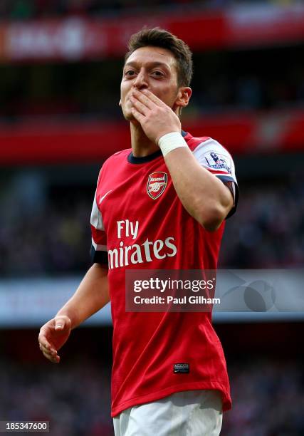 Mesut Oezil of Arsenal celebrates as he scores their second goal during the Barclays Premier League match between Arsenal and Norwich City at...