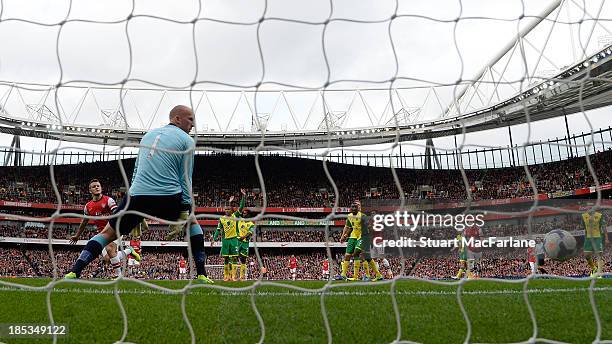 Jack Wilshere shoots past Norwich goalkeeper John Ruddy to score for Arsenal at Emirates Stadium on October 19, 2013 in London, England.