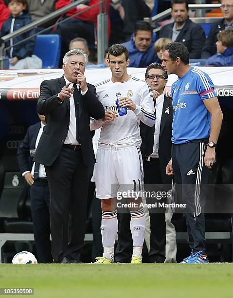 Head coach Carlo Ancelotti of Real Madrid and his assistant Paul Clement give instructions to Gareth Bale during the La Liga match between Real...