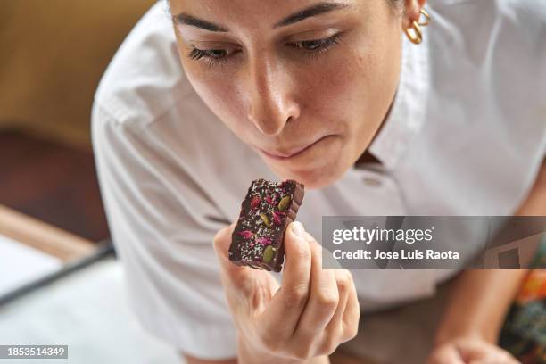 young chef woman eating chocolate - confectioner stock pictures, royalty-free photos & images