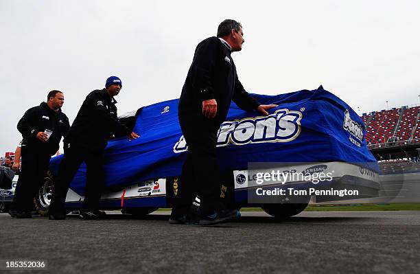 The car of Michael Waltrip, driver of the Aaron's Dream Machine Toyota, is pushed back to the garage after qualifying for the NASCAR Sprint Cup...