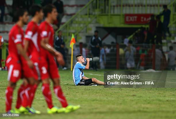 German Ferreyra of Argentina sits on the pitch as players of Iran walk by after the FIFA U-17 World Cup UAE 2013 Group E match between Iran and...
