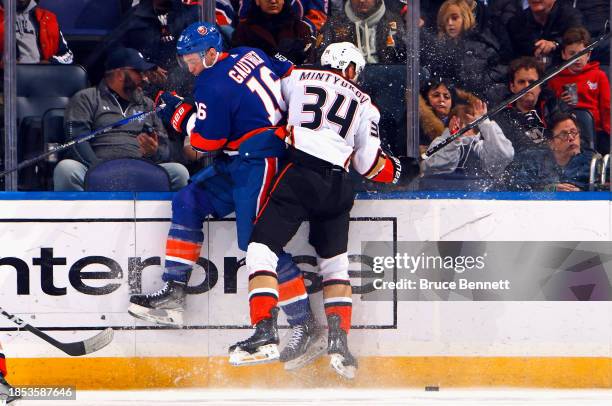 Julien Gauthier of the New York Islanders and Pavel Mintyukov of the Anaheim Ducks collide on the boards during the first period at UBS Arena on...