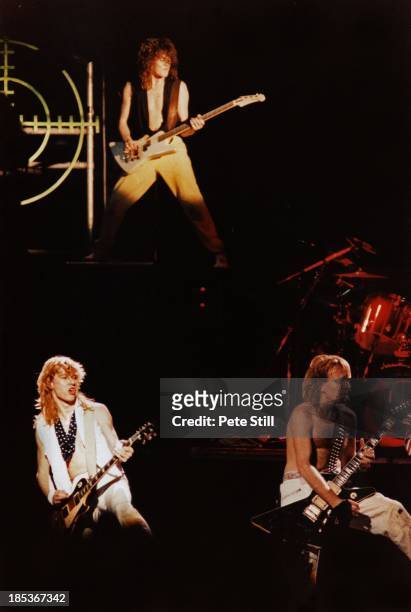 Steve Clark, Rick Savage and Phil Collen of Def Leppard perform on stage at Hammersmith Odeon, on December 5th, 1983 in London, England.