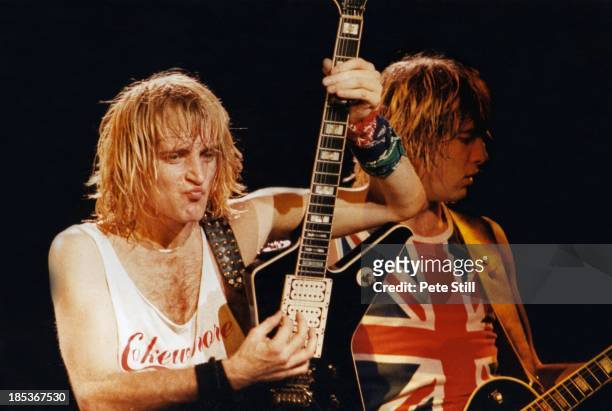 Phil Collen and Joe Elliott of Def Leppard perform on stage at Hammersmith Odeon, on December 5th, 1983 in London, England.
