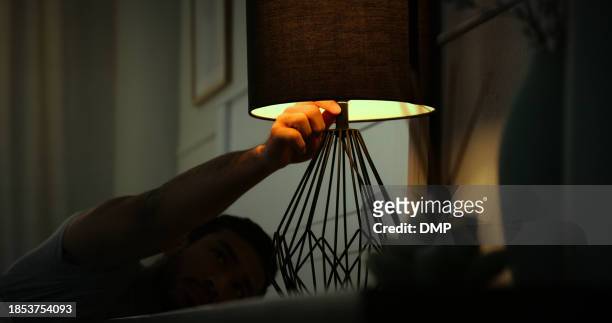 sleeping, lamp and man in dark bedroom for resting, dreaming and nap at night in home. evening, light and person with switch for wake up, prepare for evening and relax routine for comfortable in bed - turn off light stock pictures, royalty-free photos & images