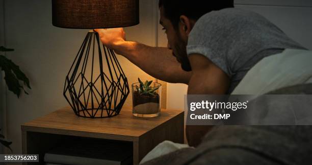 night, bed and man turn off lamp in a house for sleeping, nighttime or resting at home. light, switch and male person in bedroom for nap, peace or calm evening moment on vacation, holiday or weekend - turning on or off stock pictures, royalty-free photos & images