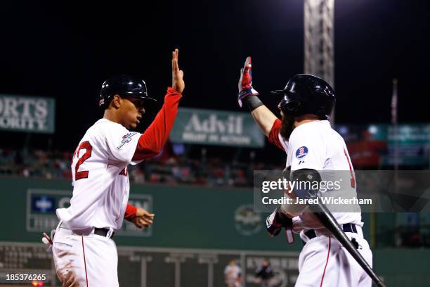 Xander Bogaerts of the Boston Red Sox celebrates with Dustin Pedroia after scoring a run off of Jacoby Ellsbury single to right against Max Scherzer...