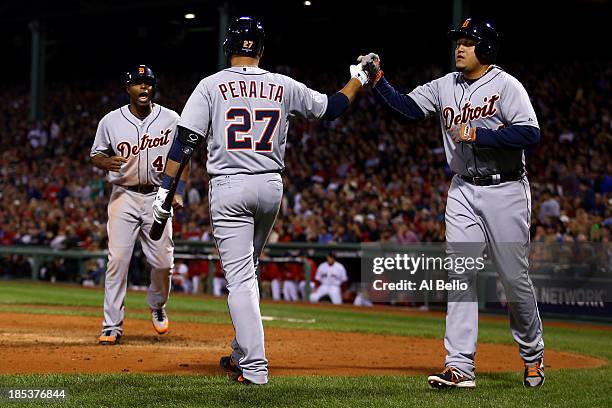 Miguel Cabrera and Torii Hunter of the Detroit Tigers celebrate with teammate Jhonny Peralta after scoring on Victor Martinez single to deep left...