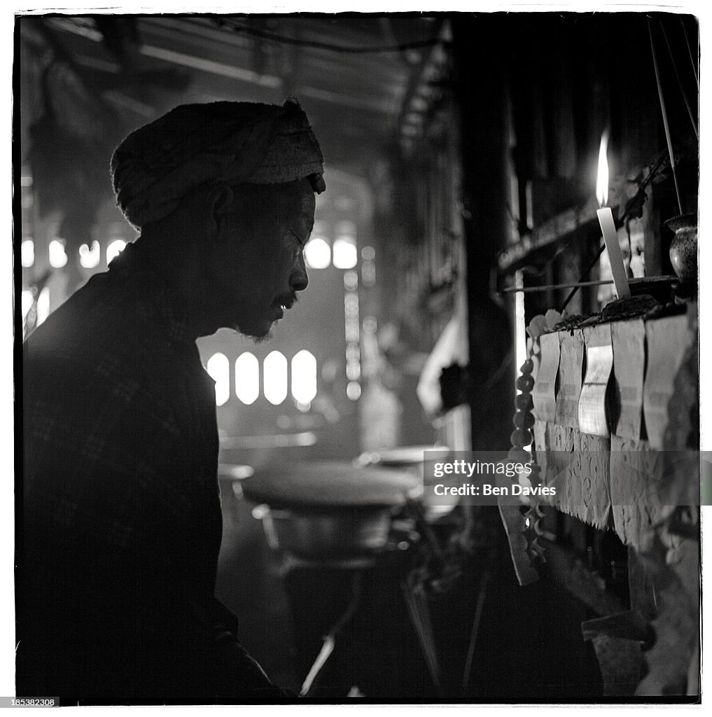 Yang Ju, 60, prays in front of a family shrine in the remote...