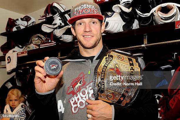 Mike Smith of the Phoenix Coyotes holds the puck from his first NHL goal against the Detroit Red Wings at Jobing.com Arena on October 19, 2013 in...