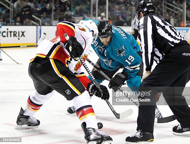 Joe Thornton of the San Jose Sharks takes a face-off against a member of the Calgary Flames during an NHL game on October 19, 2013 at SAP Center in...