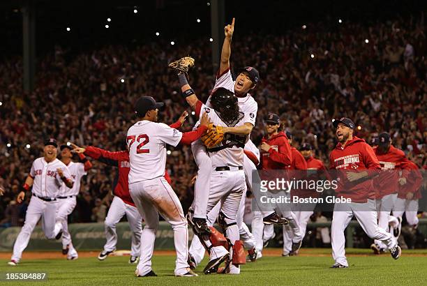 Boston Red Sox relief pitcher Koji Uehara and Boston Red Sox catcher Jarrod Saltalamacchia celebrate closing out the win and advancing to the World...