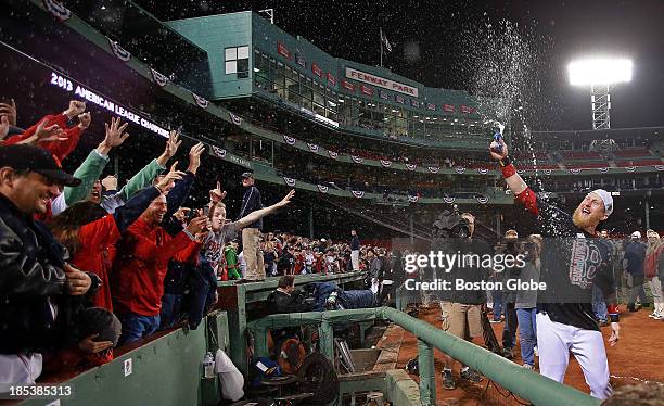 The Red Sox's Mike Carp sprays the fans in celebration. The Boston Red Sox defeated the Detroit Tigers in Game Six of the American League Champion...