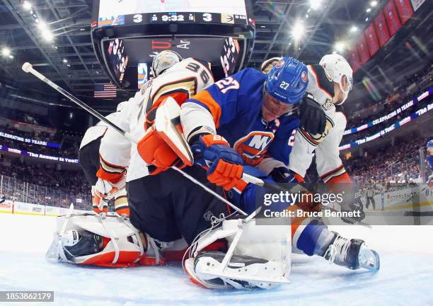 Ilya Lyubushkin and John Gibson of the Anaheim Ducks defend against Anders Lee of the New York Islanders during the third period at UBS Arena on...