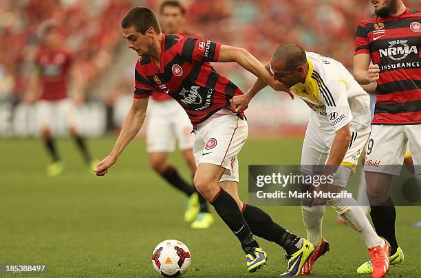 Tomi Juric of the Wanderers is challenged by Leo Bertos of the Phoenix during the round two A-League match between the Western Sydney Wanderers and...