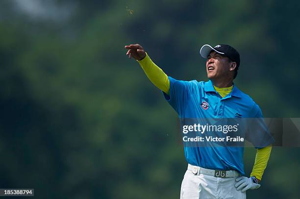 Zhang Lian-wei of China checks the wind on the 5th hole during day four of the Venetian Macau Open at Macau Golf and Country Club on October 20, 2013...