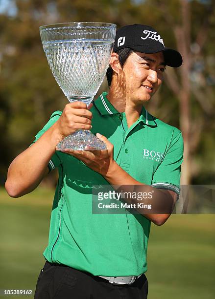 Jin Jeong of Korea holds aloft the winners trophy after winning a playoff against Ross Fisher of England during day four of the Perth International...