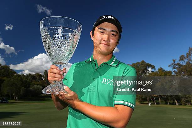 Jin Jeong of Korea holds aloft the winners trophy after winning a play-off hole against Ross Fisher of England on at the 3rd green during day four of...