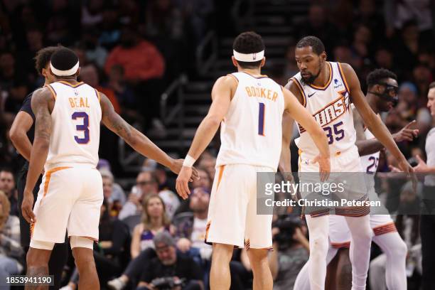 Kevin Durant of the Phoenix Suns high fives Bradley Beal and Devin Booker during the second half of the NBA game against the Brooklyn Nets at...