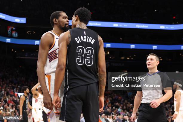 Kevin Durant of the Phoenix Suns and Nic Claxton of the Brooklyn Nets react during the first half of the NBA game at Footprint Center on December 13,...