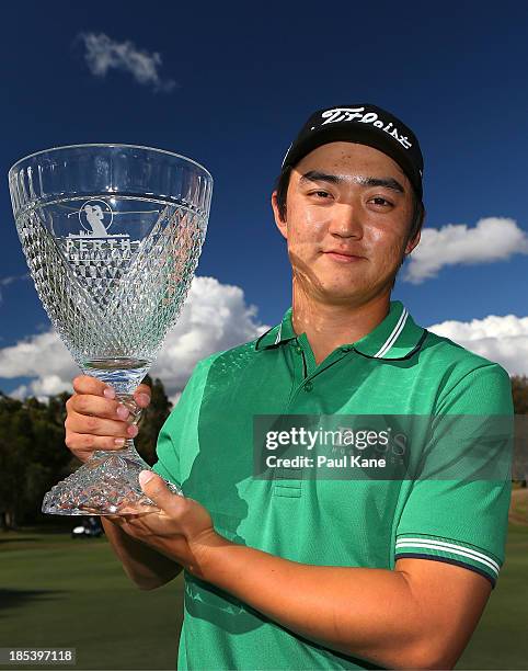 Jin Jeong of Korea holds aloft the winners trophy after defeating Ross Fisher of England on a play-off hole to win the tournament during day four of...