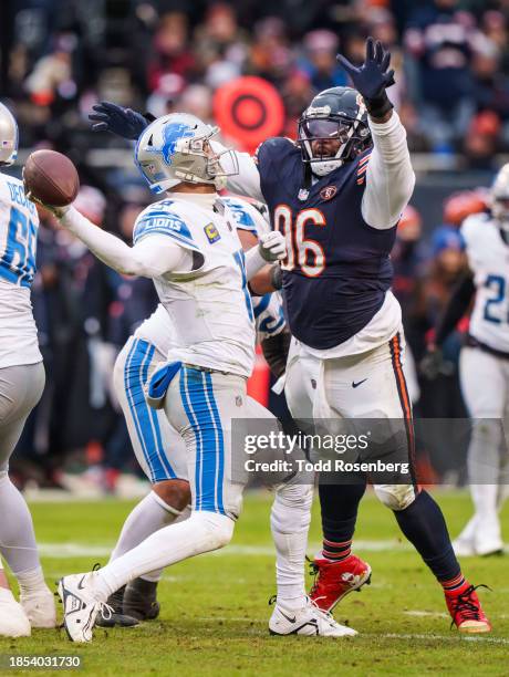 Quarterback Jared Goff of the Detroit Lions attempts to pass the ball over tight coverage by defensive tackle Zacch Pickens of the Chicago Bears...