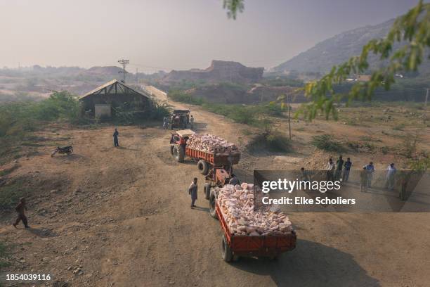 Trucks with industrial salt leave the Khewra salt mine on December 13, 2023 in Jhelum, Pakistan. Accounting for roughly 800 million pounds of salt...