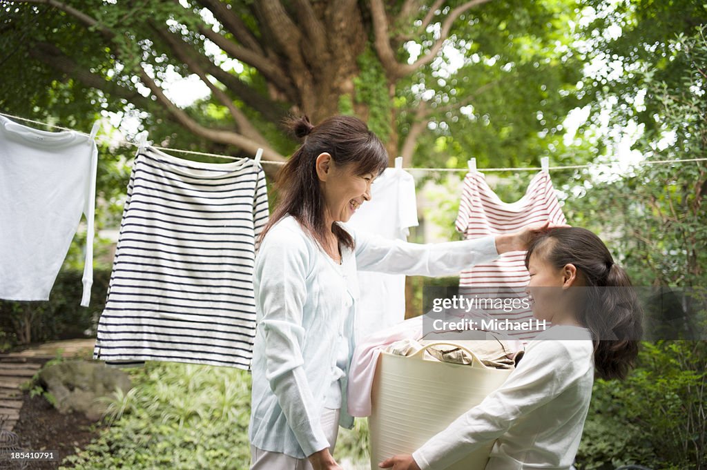 A girl helps grandma's laundry in the garden