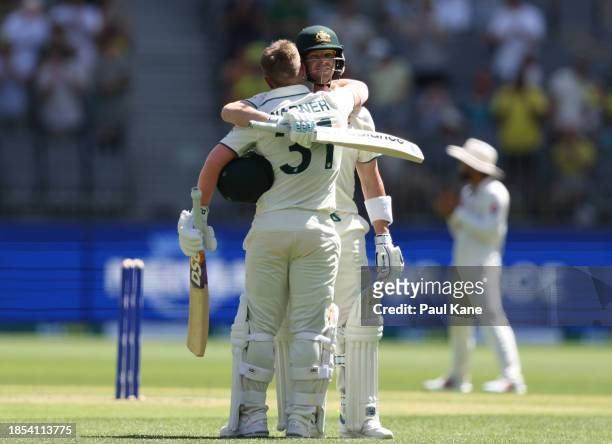 David Warner of Australia celebrates with Steve Smith after scoring a century during day one of the Men's First Test match between Australia and...