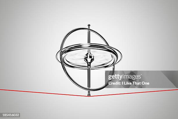 spinning gyroscope, balancing on a red cable - balanced stock pictures, royalty-free photos & images