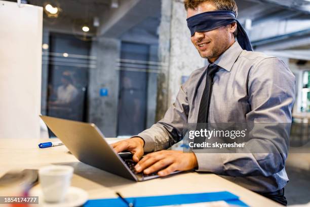 blindfolded businessman unable to see the reality over computer in the office. - oblivious stock pictures, royalty-free photos & images