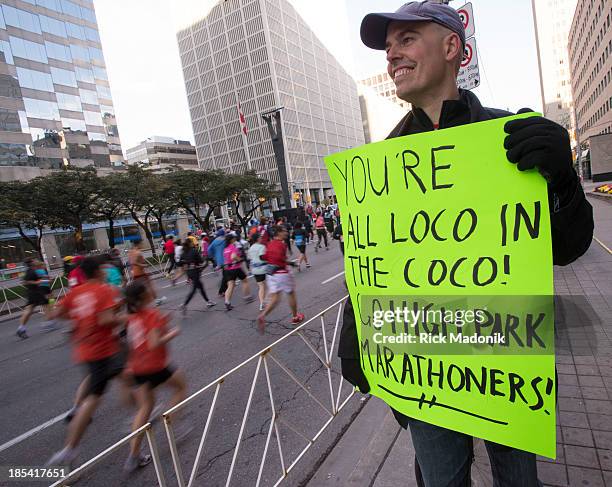 Andrew Dundas, whose fiancé and some friends are in the race, holds a sign which got a lot of attention from the runners. Scotiabank Toronto...