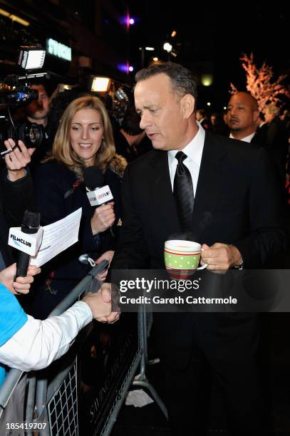 Tom Hanks drinks a cup of tea as he talks to reporter on the red carpet of the Closing Night Gala European Premiere of "Saving Mr Banks" during the...