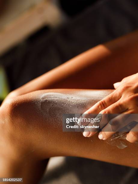 appliquer une lotion solaire! - jambe photos et images de collection