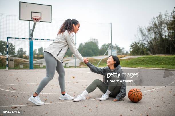 helfende hand nach basketball-sturz - osteuropa stock-fotos und bilder