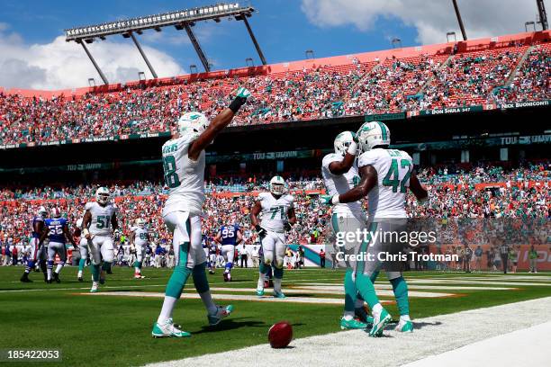 Charles Clay of the Miami Dolphins is congratulated on his touchdown by his teammates Rishard Matthews of the Miami Dolphins and Brandon Gibson of...