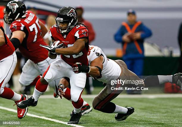 Jacquizz Rodgers of the Atlanta Falcons rushes against Daniel Te'o-Nesheim of the Tampa Bay Buccaneers at Georgia Dome on October 20, 2013 in...