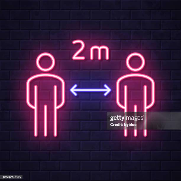 soziale distanzierung - 2 meter. leuchtende neon-ikone auf backsteinwandhintergrund - light meter stock-grafiken, -clipart, -cartoons und -symbole